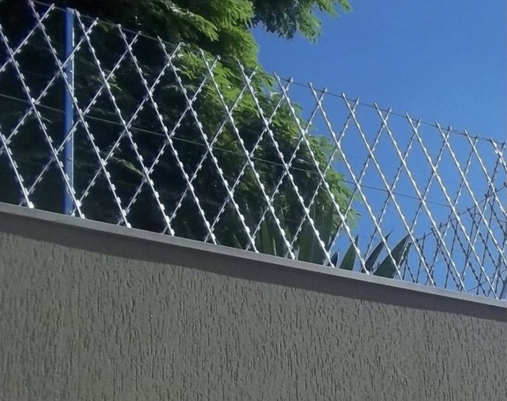 Cerca laminada galvanizada instalada sobre muro — serviço executado pela Renovare